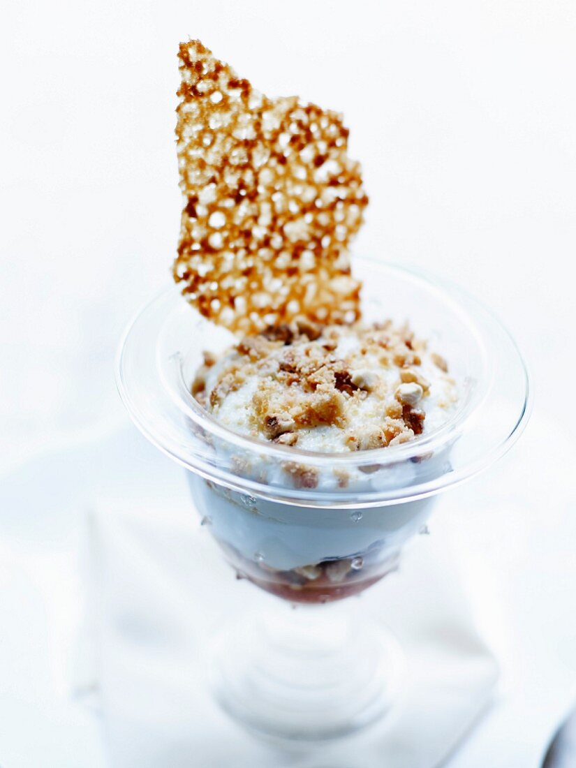 Toffee and crushed dried fruit creamy dessert with crispy caramel tuile