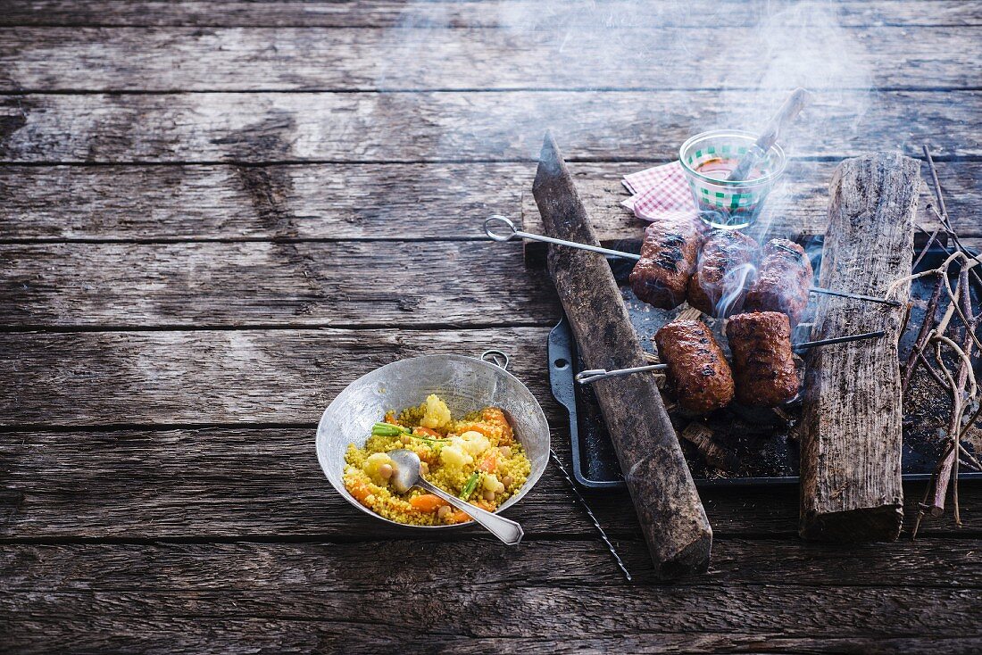 Cooking turkey sausages on the barbecue,curried semolina with vegetables