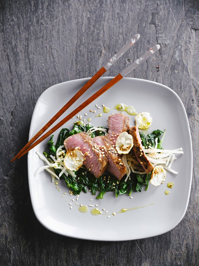 Veal with honey,sesame seeds,tender spinach and black radish