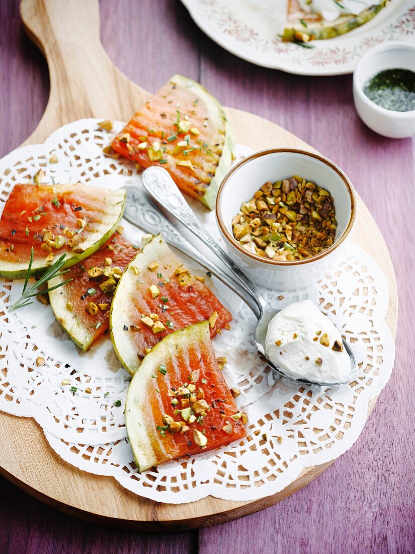 Gegrillte Wassermelone mit gehackten Pistazien und Schlagsahne