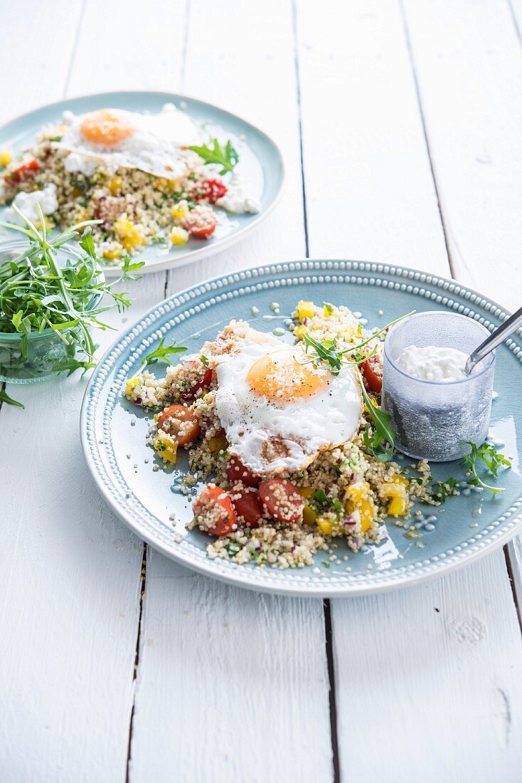 Quinoa salad with tomatoes, yellow peppers, fried egg and cottage cheese