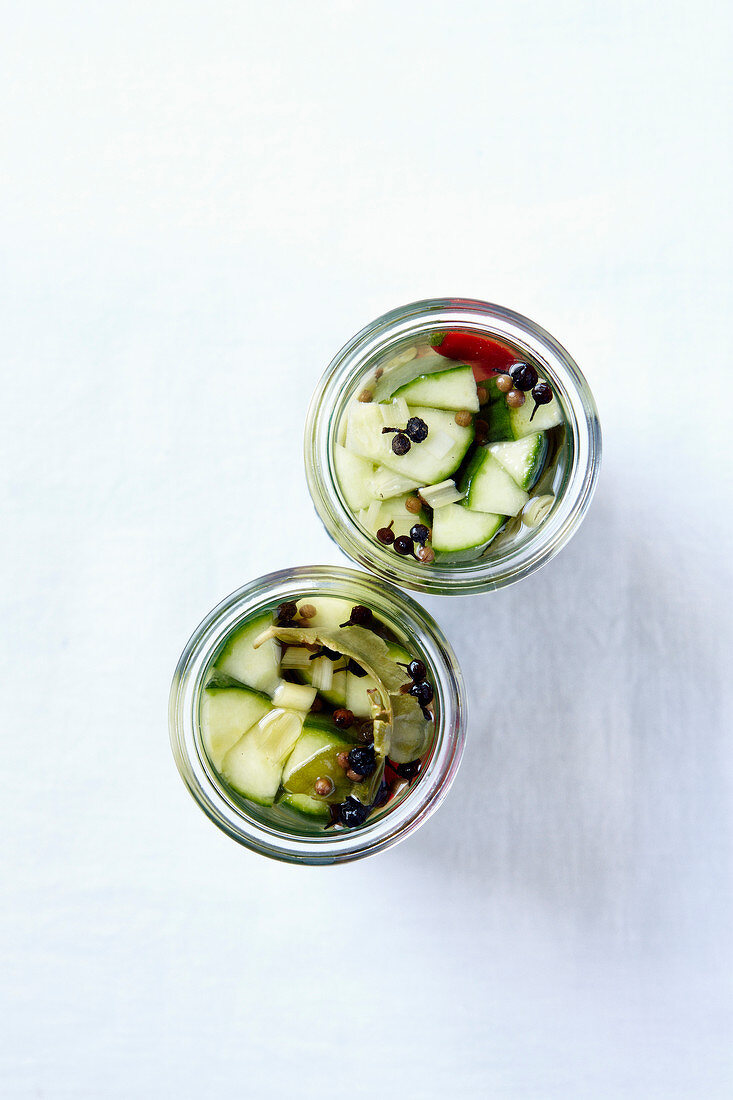 Pickled cucumbers with chilies and spices in preserving jars