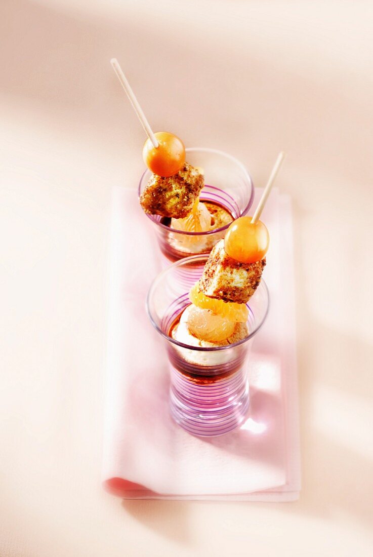 Fresh fruit and caramelized cubes of fromage frais en brochette, scoop of ice cream