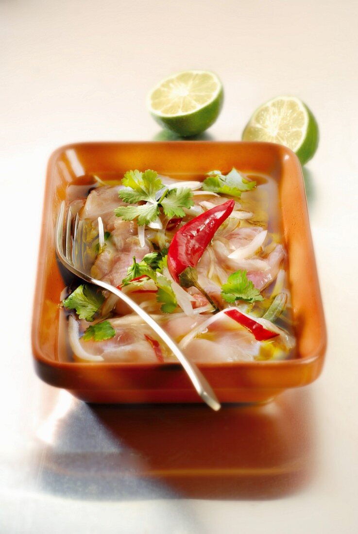Pink seabream marinating with onions, chili peppers, lime and coriander