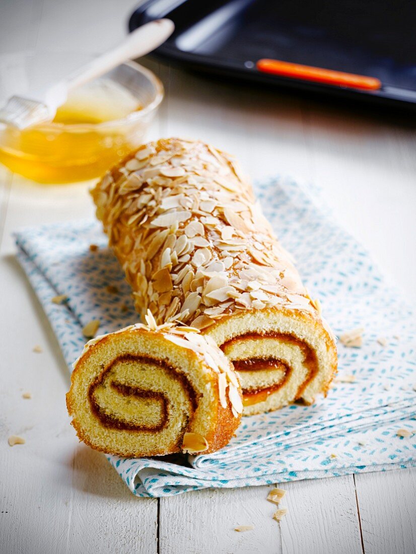 Apricot jam rolled sponge cake coated with thinly sliced grilled almonds