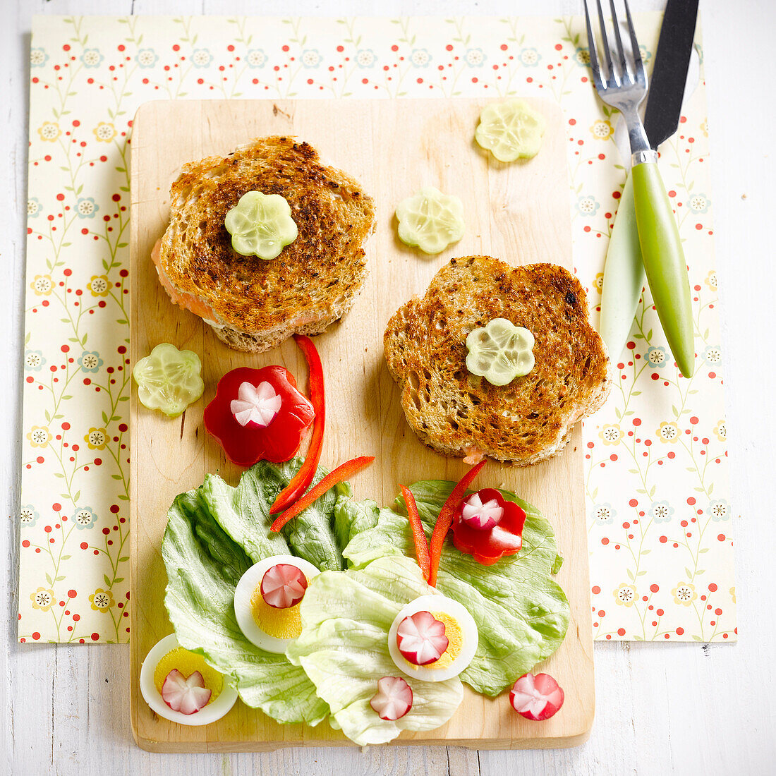 Croque-Monsieurs (Getoastetes Schinken-Käse-Sandwiche) mit Salatblättern in Blumenform angerichtet