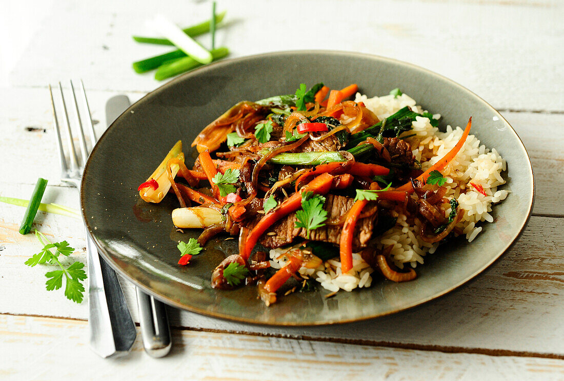 Stir-fried veal cutlets with soy sauce and vegetables on rice