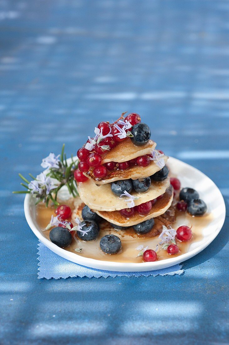 Pancakes with blueberries,redcurrants and maple syrup with rosemary