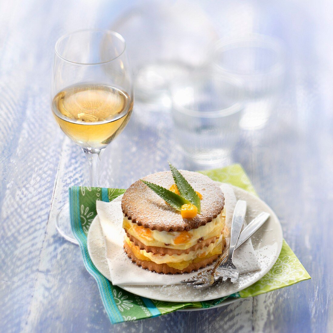 Mango and pineapple shortbread mille-feuille, glass of sweet white wine