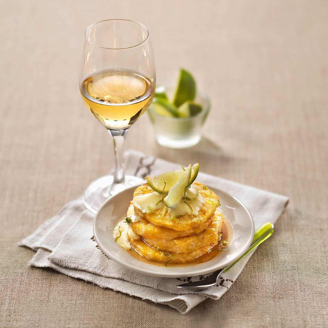Roasted pineapple with hazelnut butter and thick lime cream, glass of sweet white wine