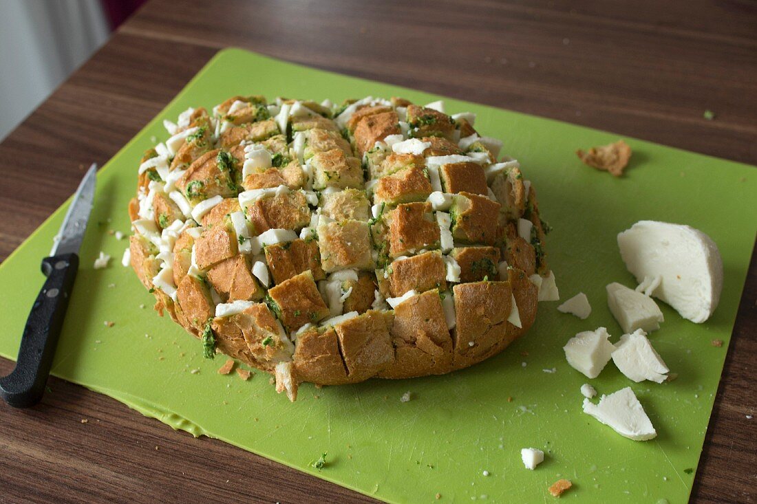 Mozzarellastückchen in eingeritztes Brot füllen