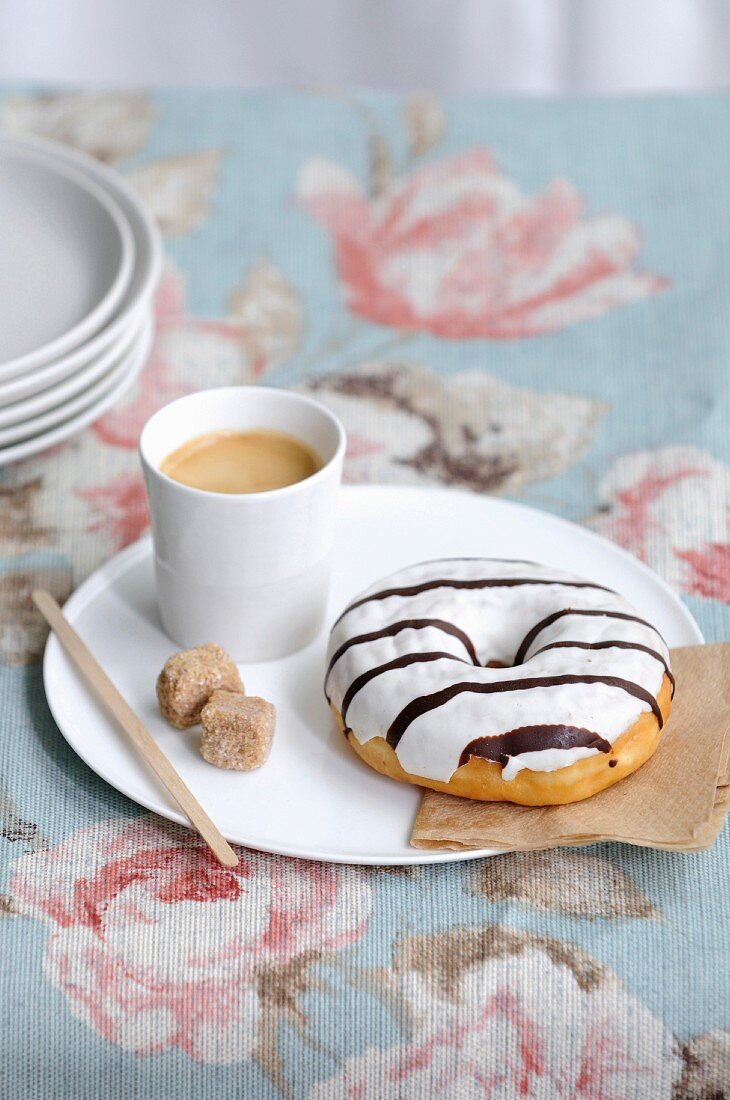 Donut mit Zuckerglasur und Tasse Espresso