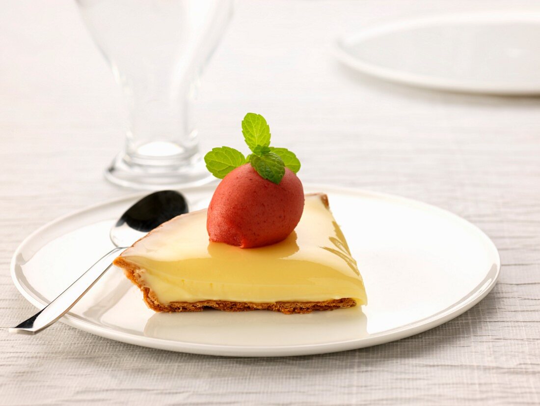 Slice of lemon curd pie topped with strawberry sorbet