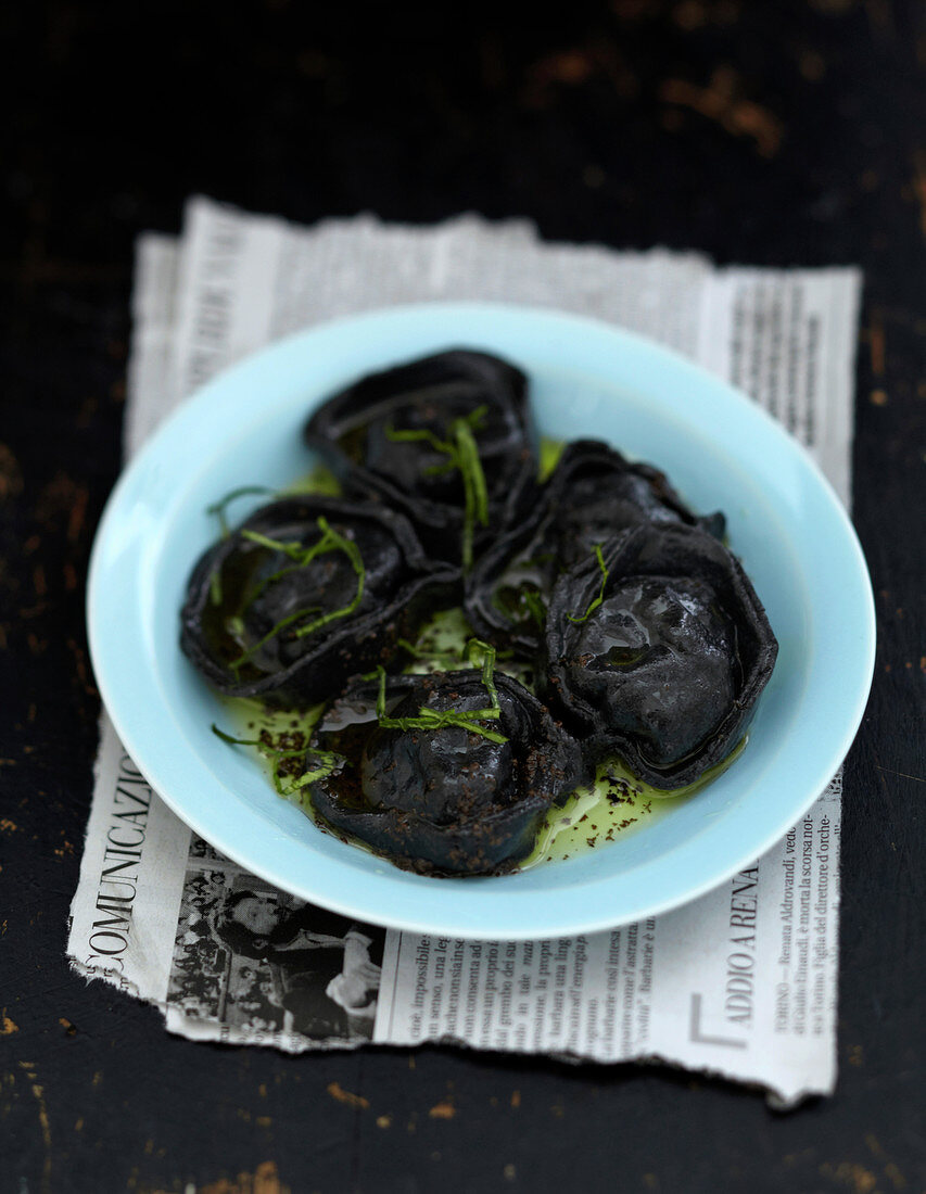 Black tortellini with truffle oil and chopped herbs