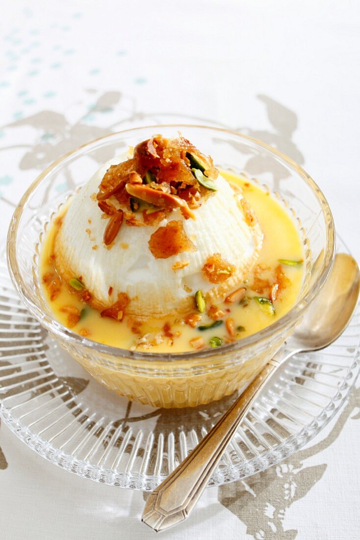 A floating island (an egg white dumpling in vanilla sauce) with caramel and dried fruit