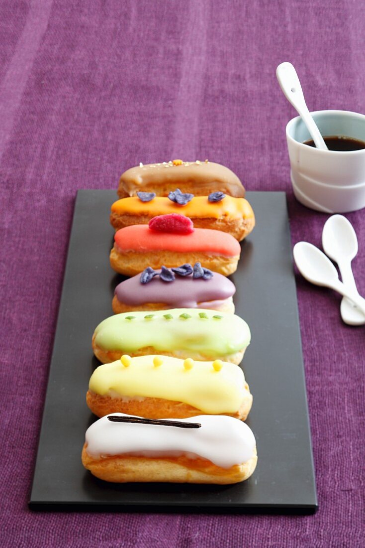 Various mini eclairs on a black platter