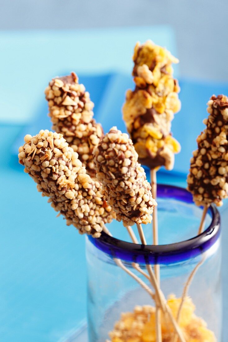 Sweet brochettes coated with chocolate and two cereals