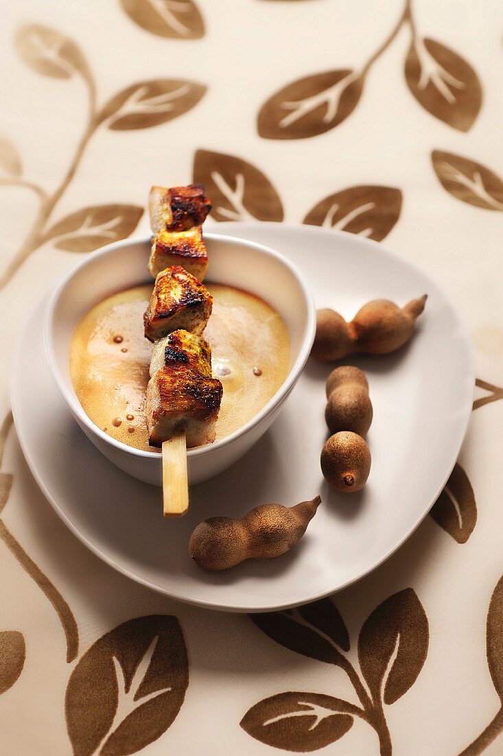 Chicken skewers with satay sauce and curry foam