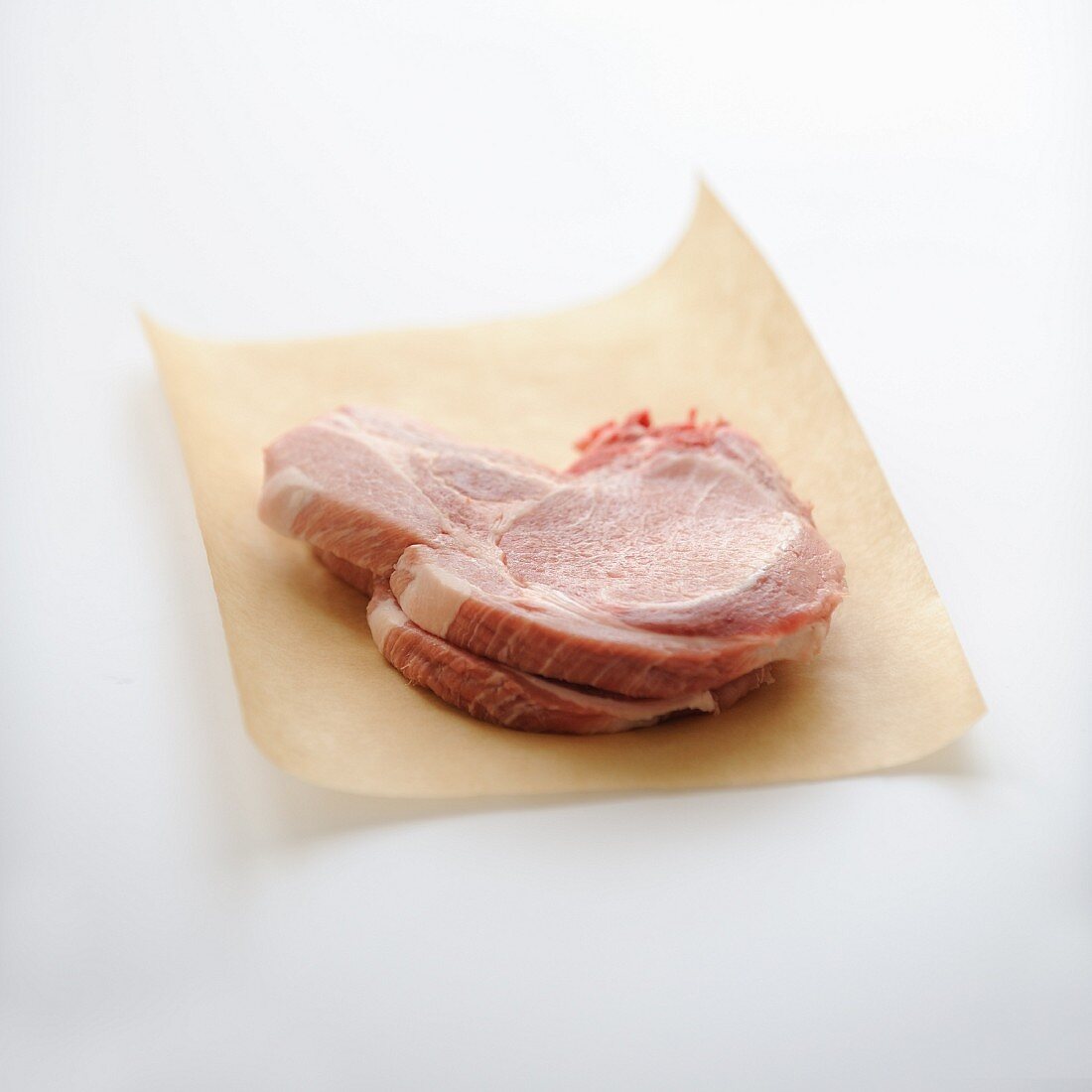 Raw pork chops on brown paper