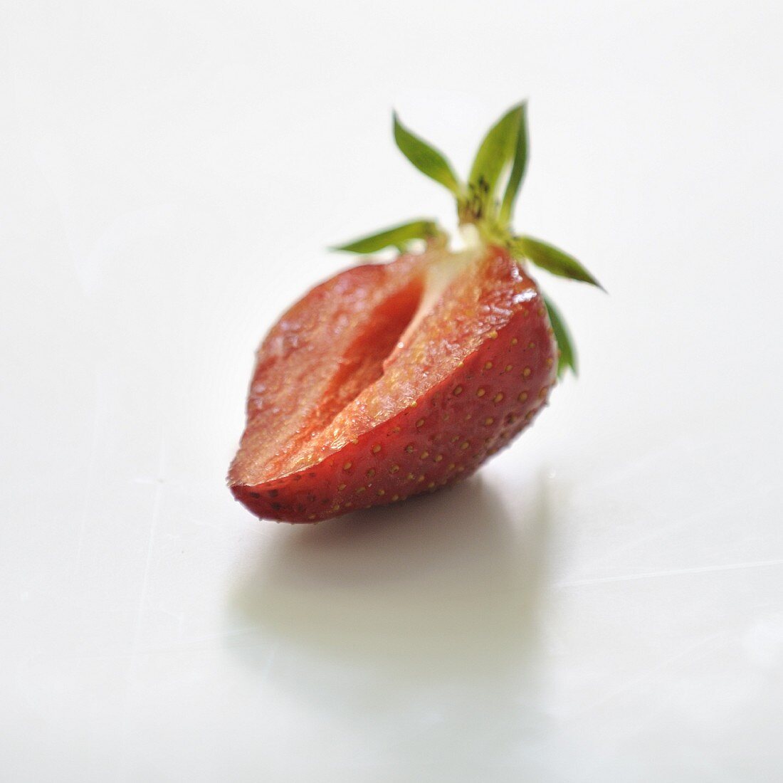 Halbierte Erdbeere vor weißem Hintergrund
