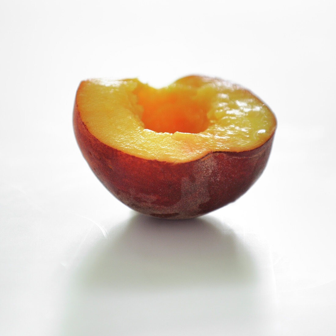 Halber Pfirsich vor weißem Hintergrund