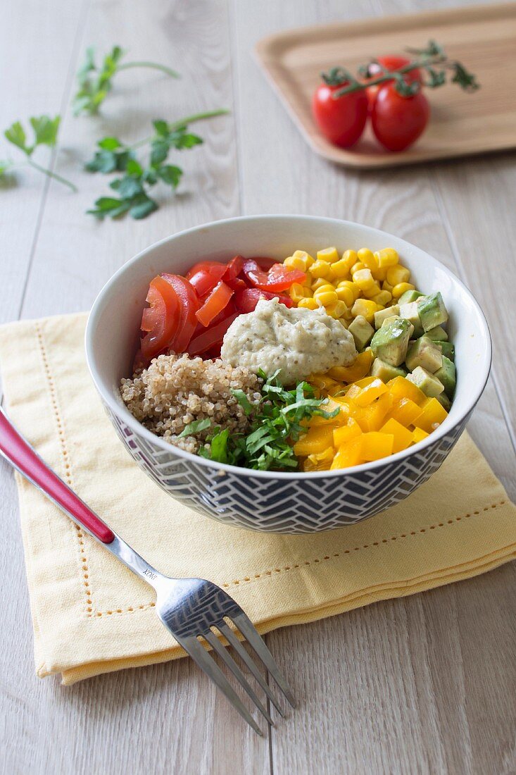 Tomato, avocado, sweet corn, mango and aubergine caviar Buddha bowl