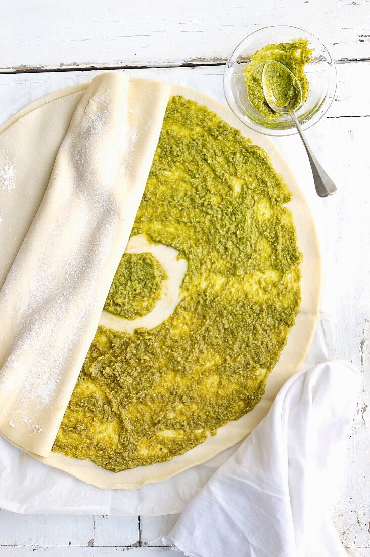 Spreading the pesto paste onto the round sheet of filo pastry and cover with another one