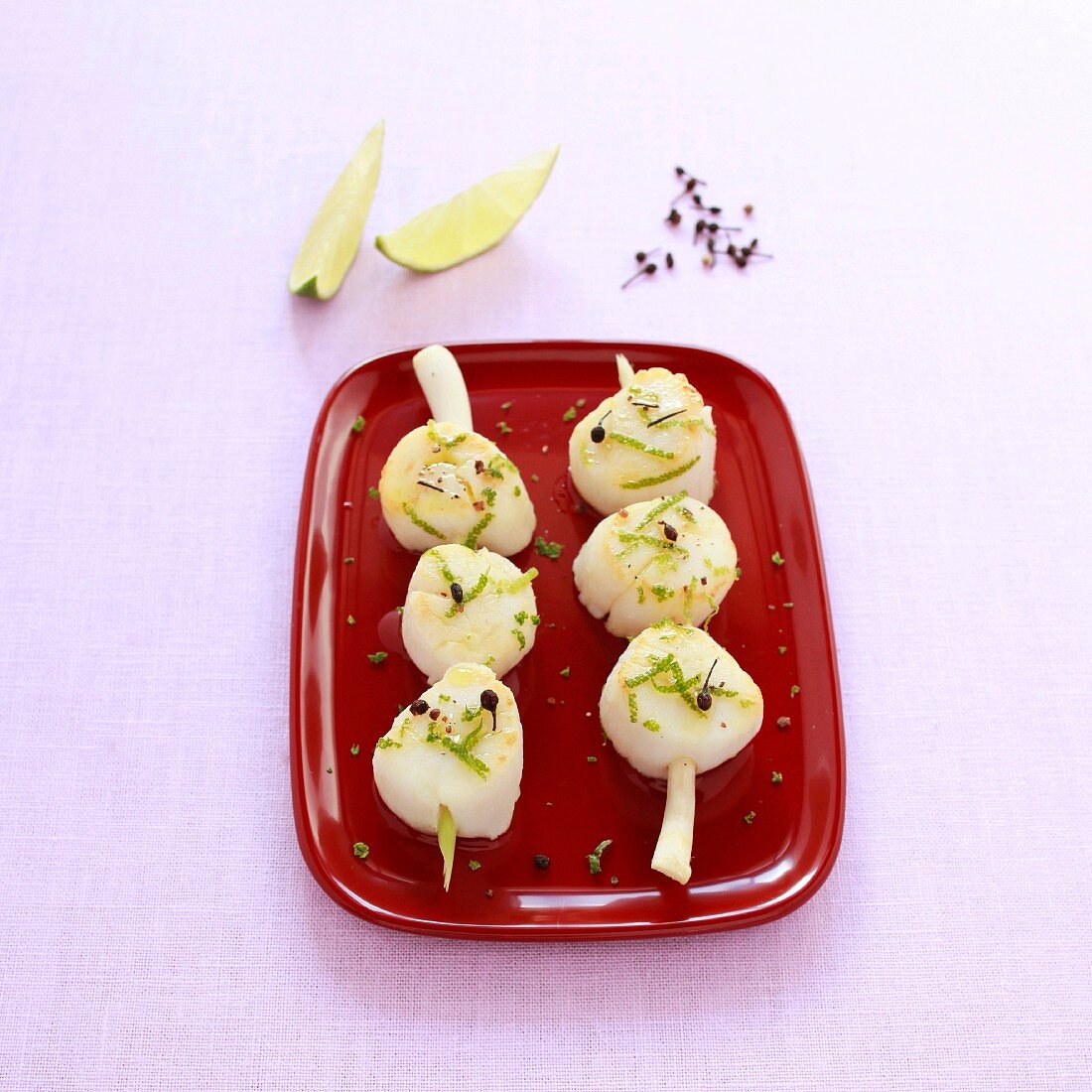 Scallop brochettes with lime and pepper on a citronella stalk