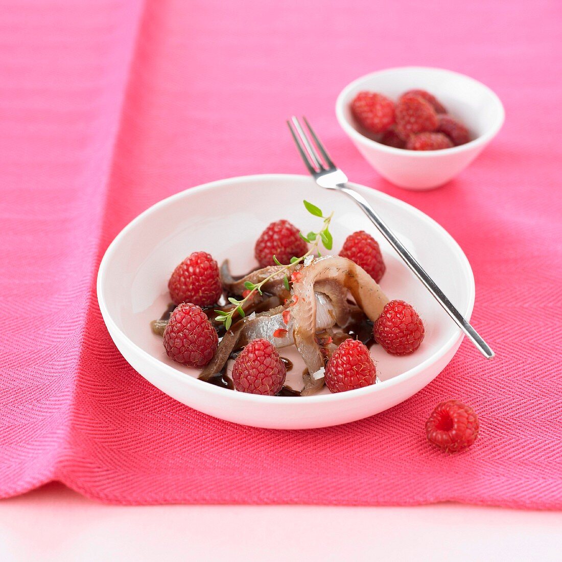 Roher Hering mit Himbeeren und Balsamicosahne