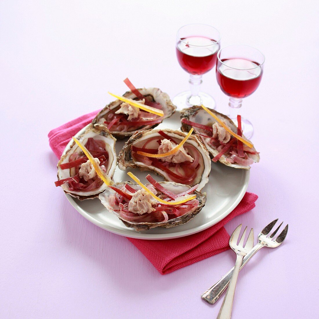 Oysters with thinly sliced bresaola, red onions, confit orange rinds and tuna crumbs