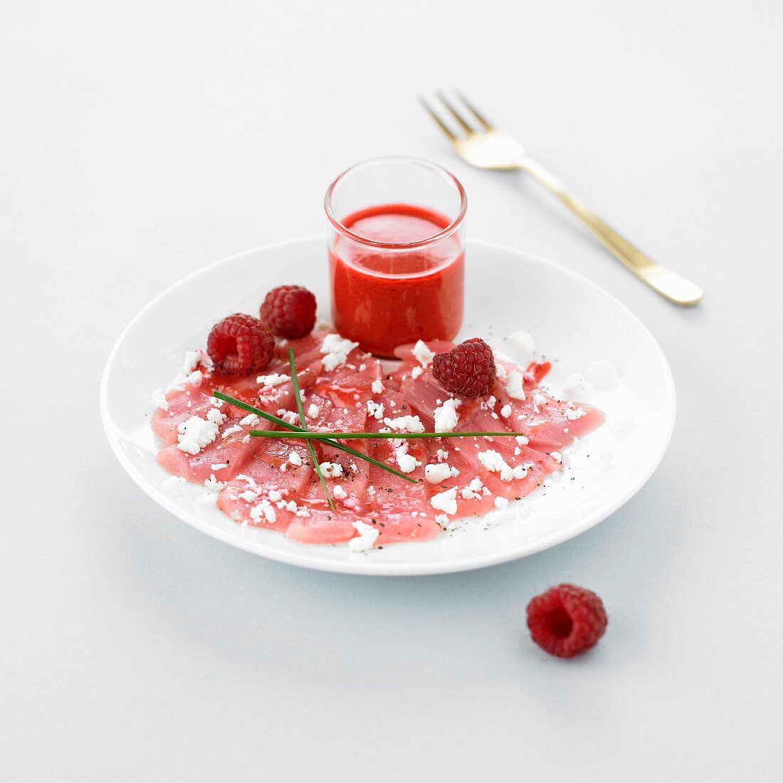 Red tuna carpaccio, feta crumbs and raspberry coulis