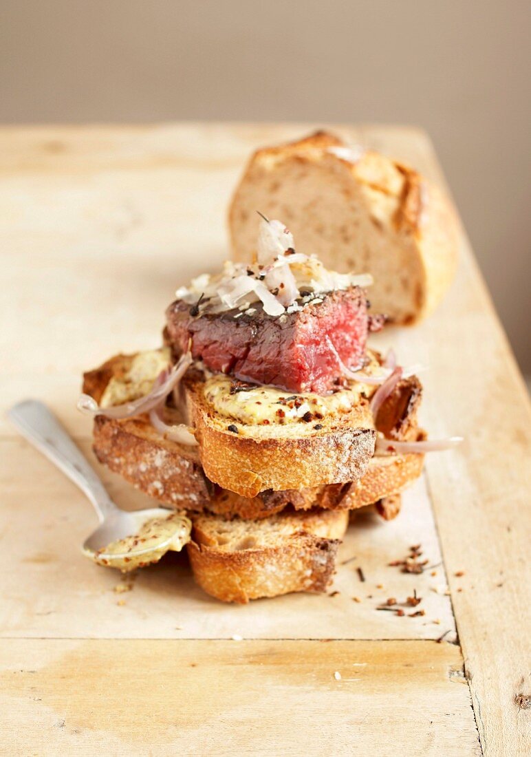 Beef back steak with shallots and mustard on sliced bread