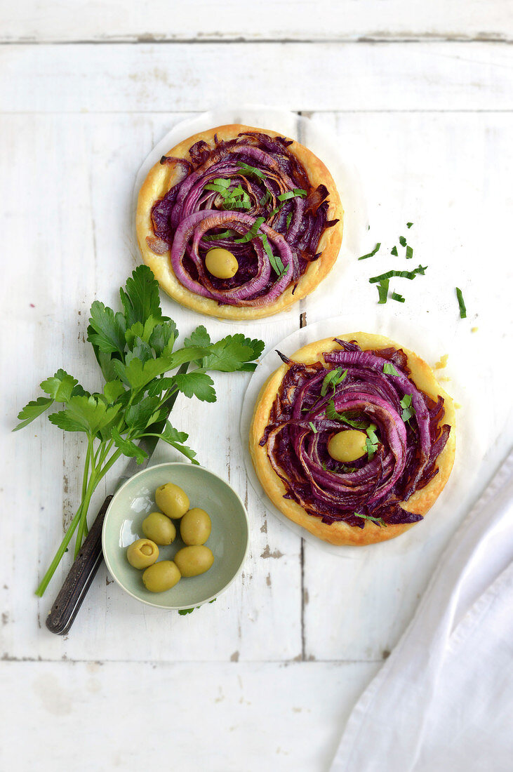 Feine Tartelettes mit roten Zwiebeln und grünen Oliven.