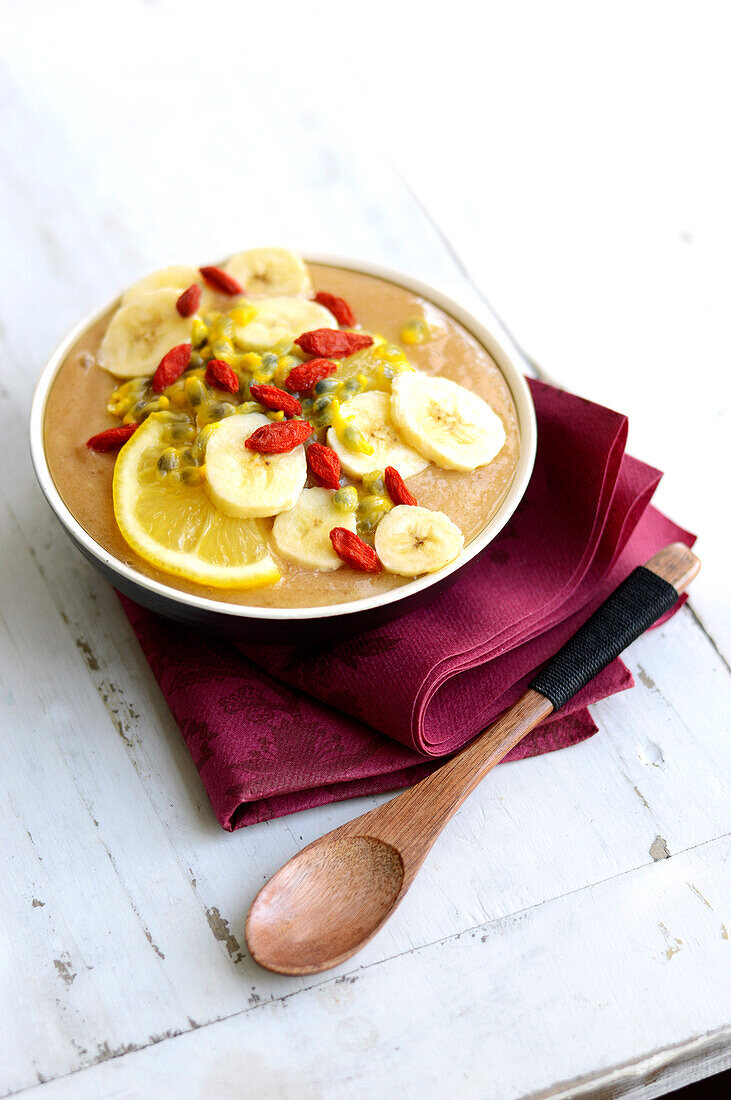 Smoothie-Bowl mit Banane, Zitrone, Passionsfrüchten und Gojibeeren (vegan)