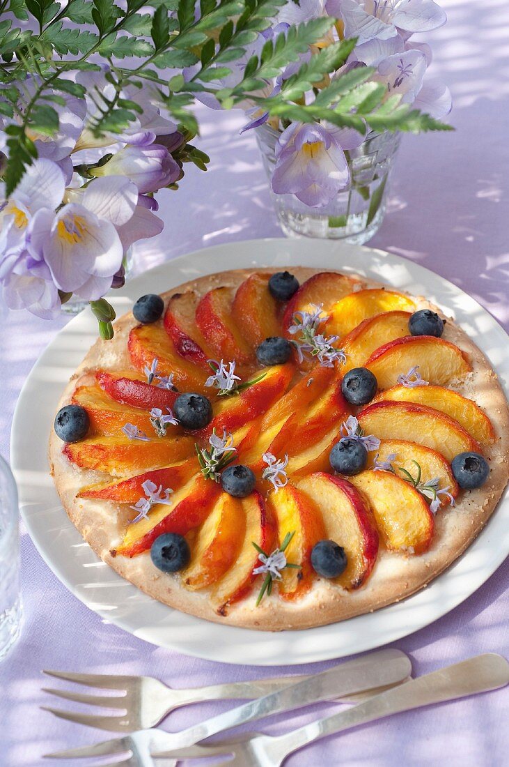 Dünne Tarte mit Nektarinen, Heidelbeeren und Rosmarinblüten