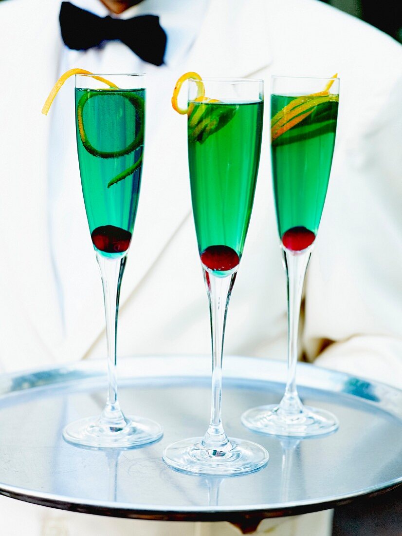 Waiter carrying a tray with 3 glasses of Royal Mint cocktail