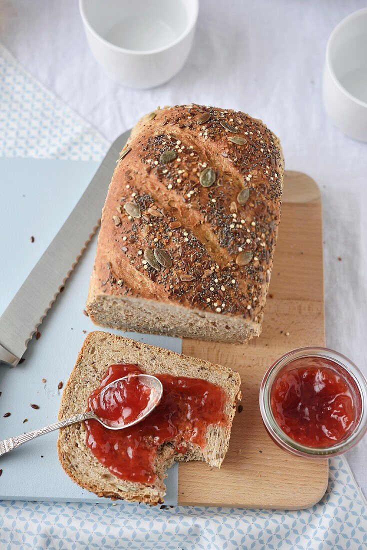 Slice of cereal bread with redcurrant jam