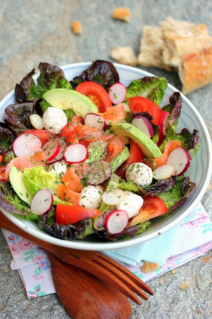 Salat mit Räucherlachs, Avocado, Mozzarellabällchen und Radieschenscheiben