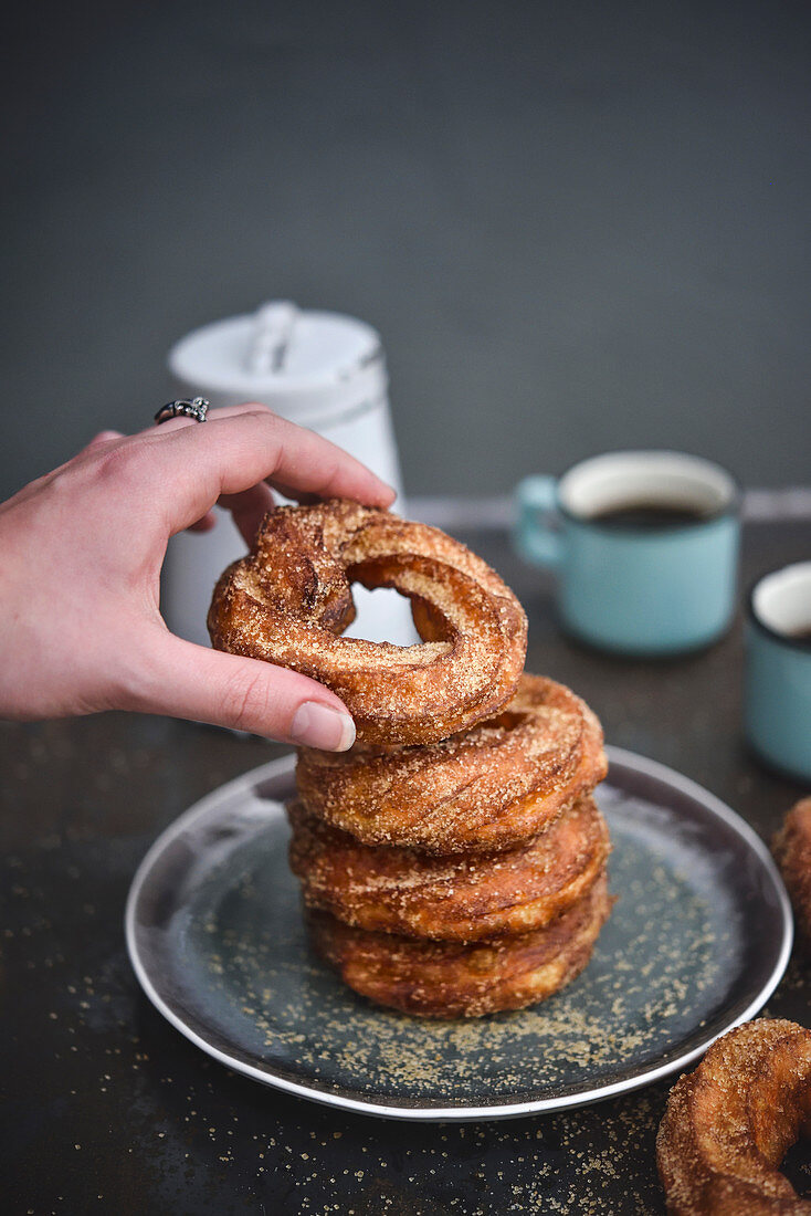 Hand taking a donut from the top of the pile