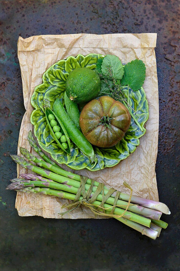 Green asparagus, black tomatoes, podded peas and lime