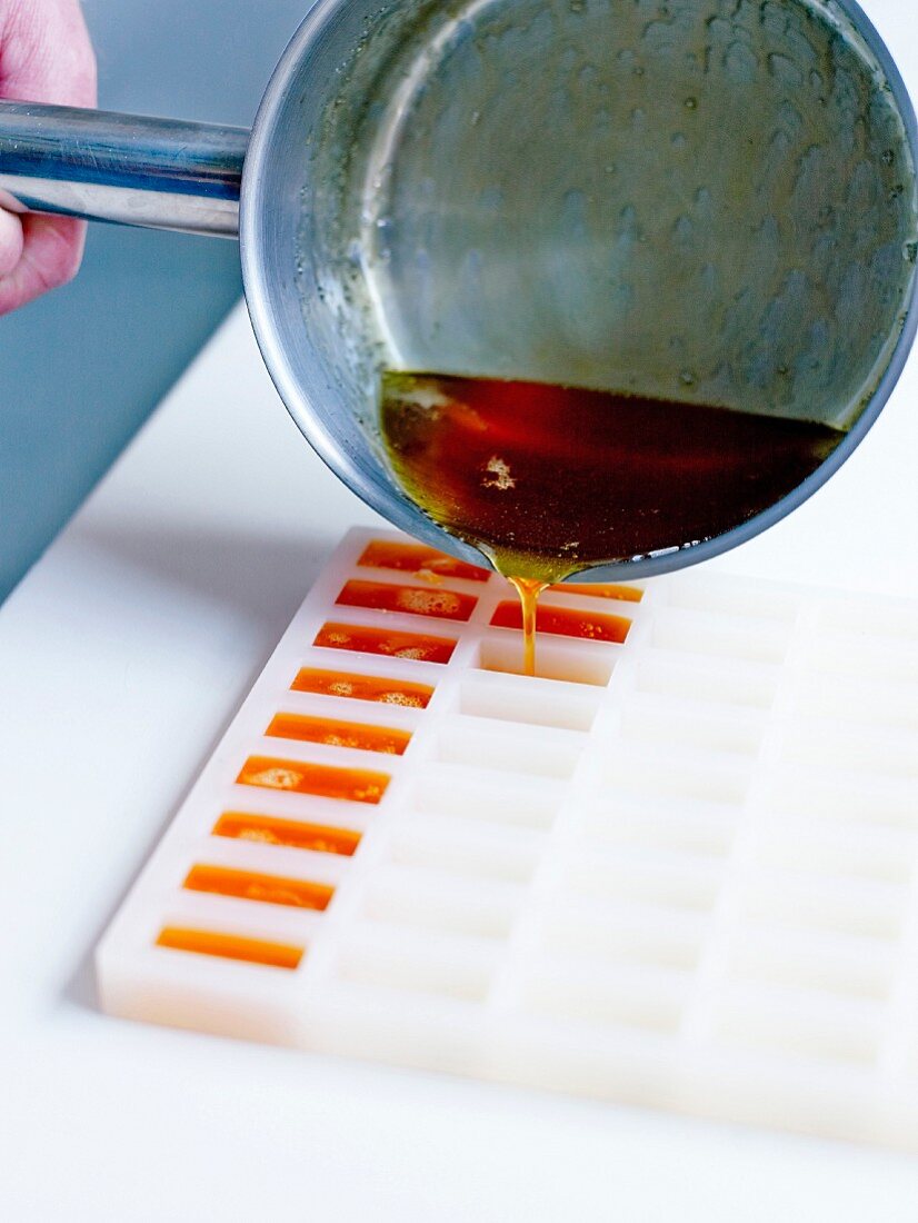 Pouring the hot syrup into small rectangular silicone molds