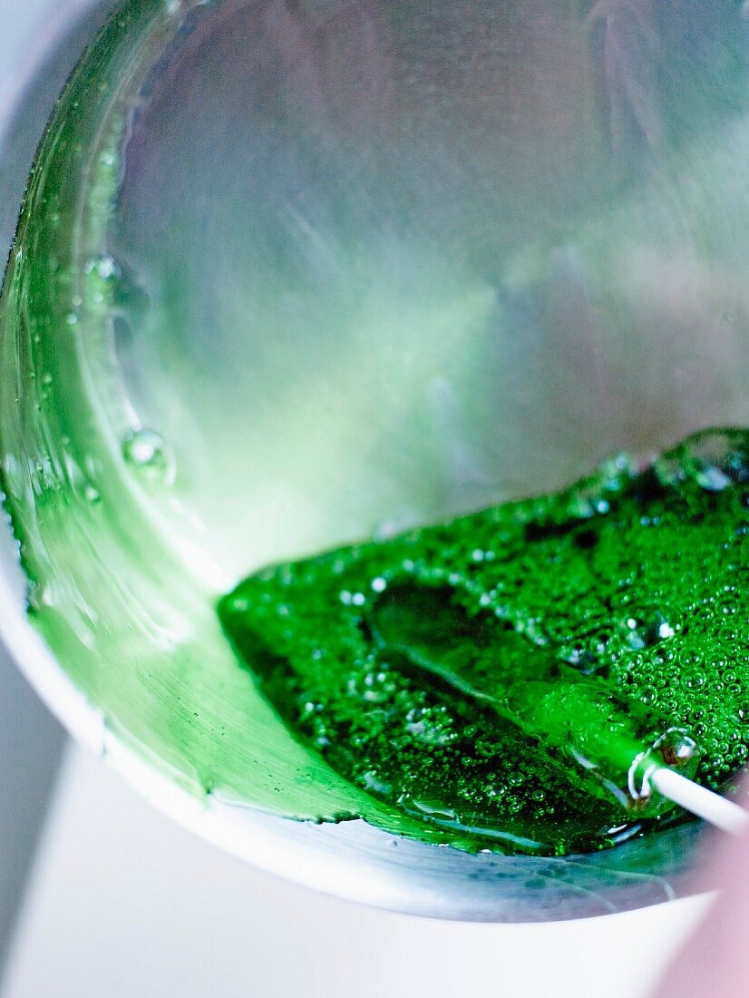 Dipping the cold mint lollipop in a hot sugar frosting