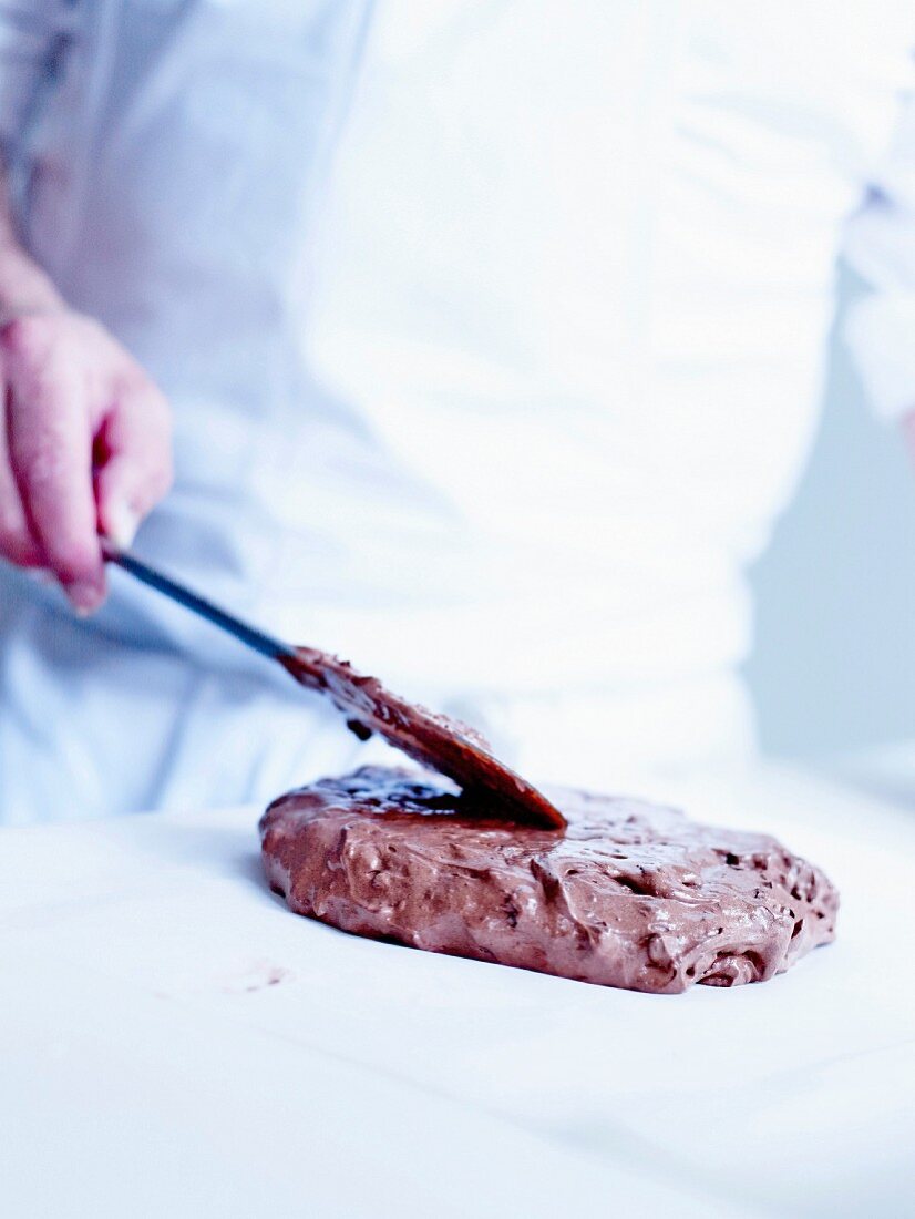 Spreading out the marshmallow preparation on wax paper