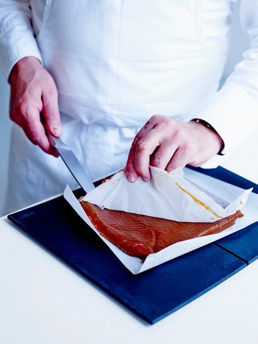 Removing the sheet of wax paper covering the caramel