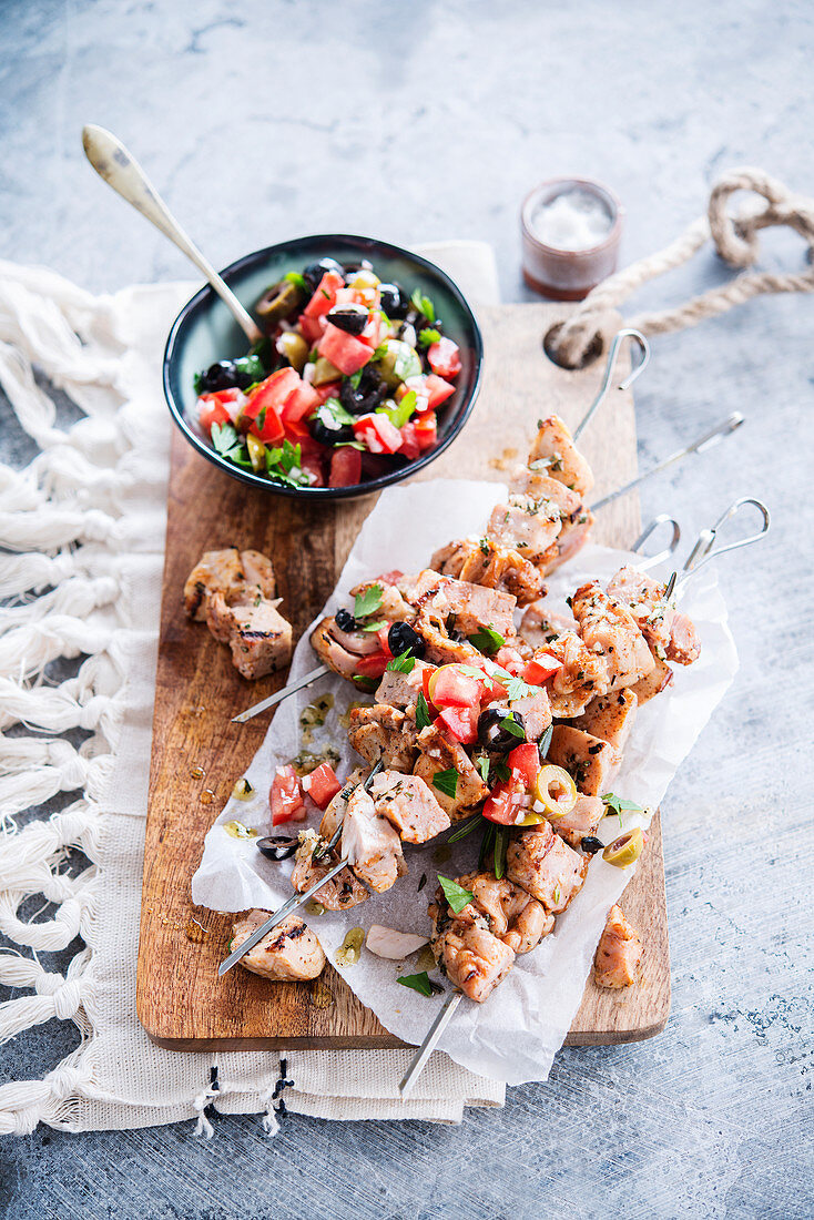 Chicken skewers, tomato salad with two olives