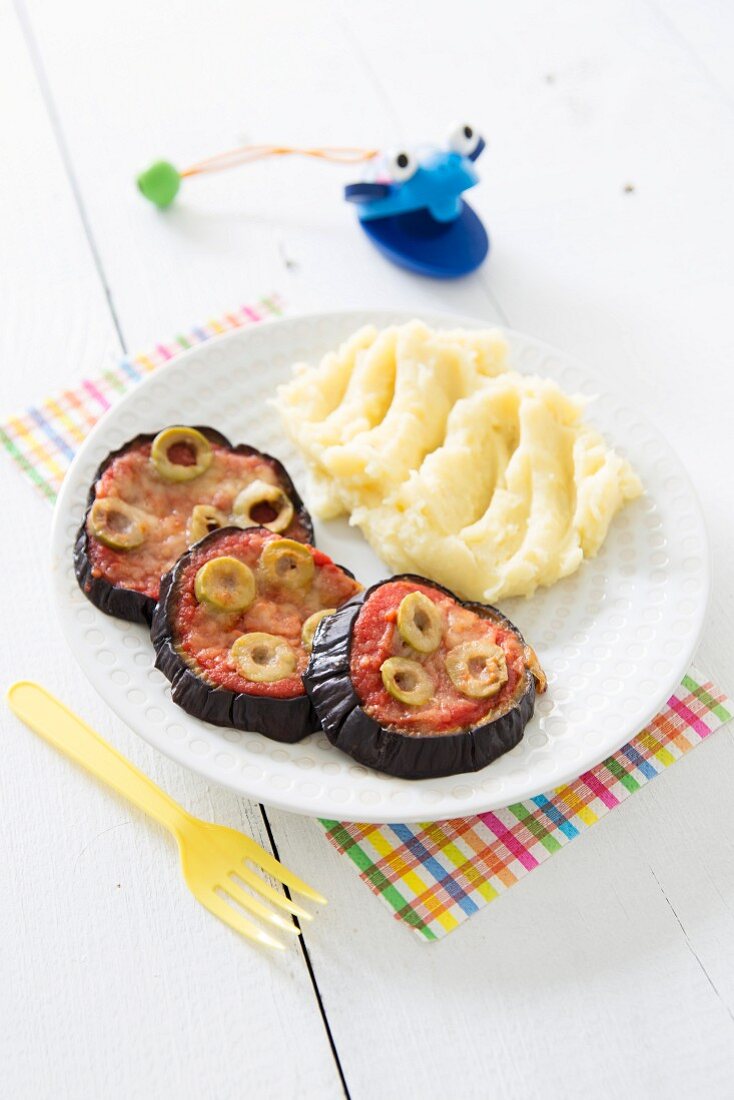 Mini Auberginen-Pizzen mit Tomaten und Oliven, dazu Kartoffelpüree