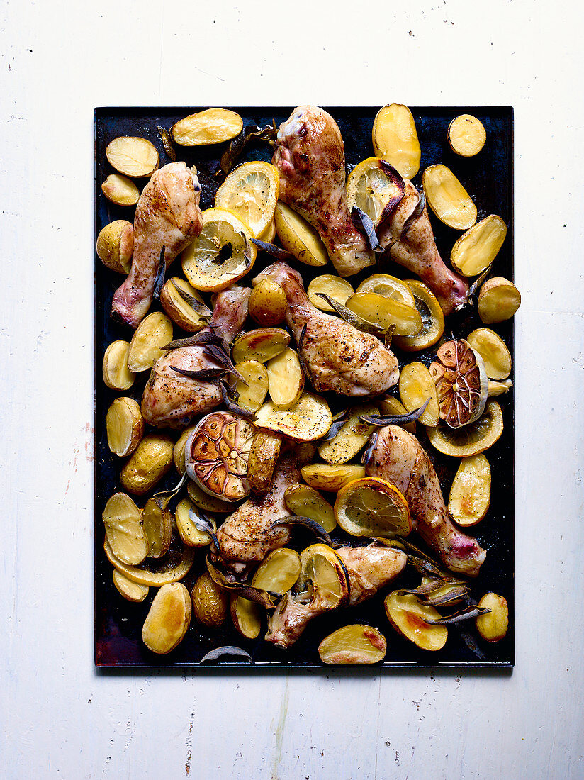 Hähnchenkeulen aus dem Ofen mit Zitronen, Kartoffeln und Knoblauch