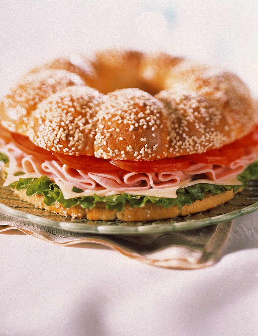 Sesamring-Sandwich mit Schinken, Käse und Tomaten