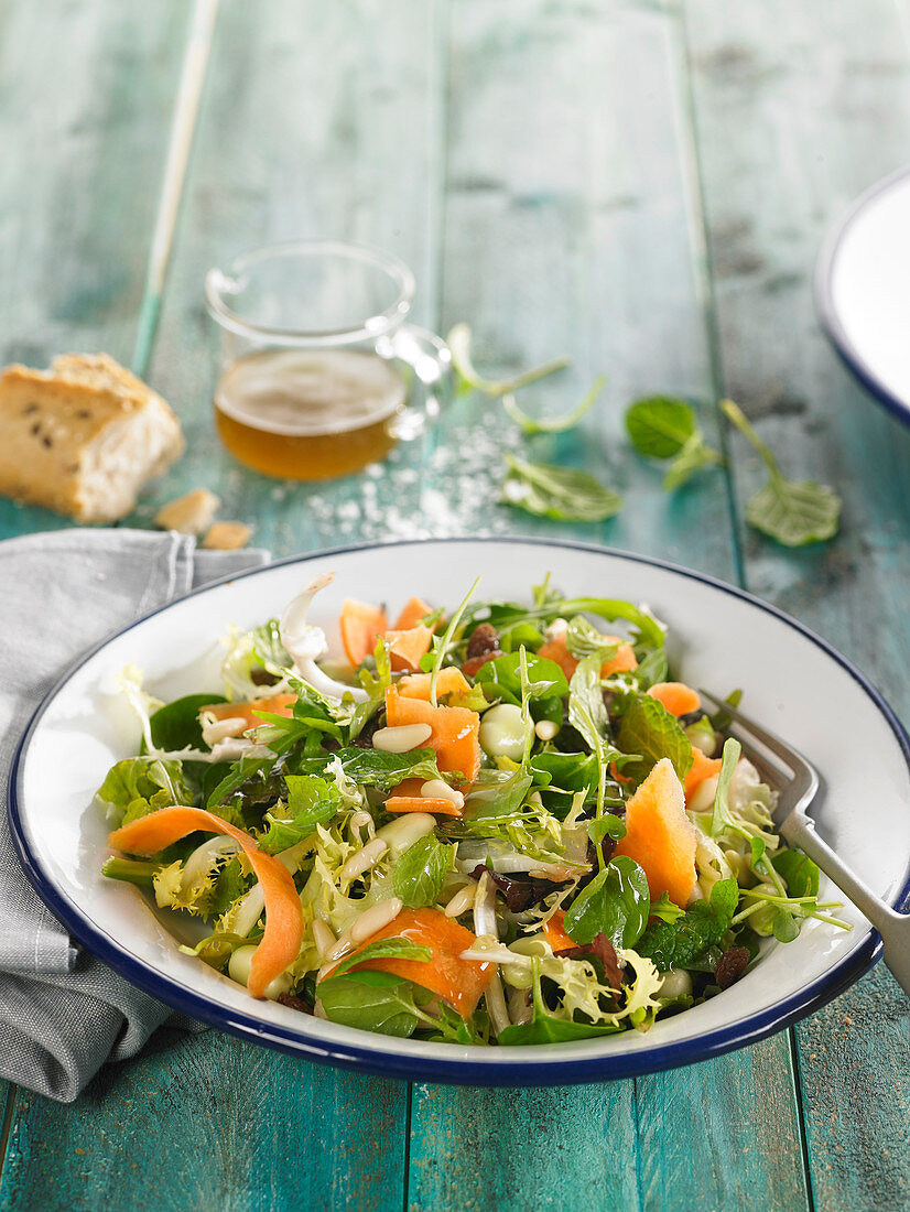 Gemischter grüner Salat mit Möhren, dicken Bohnen, Rosinen und Pinienkernen (vegan)