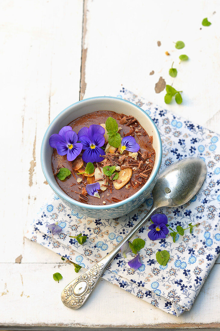 Chocolate mousse with almonds, hazelnuts and pansy flowers
